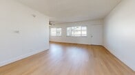 Located at 3910 Coco Ave in the Baldwin Hills neighborhood of Los Angeles, this well-maintained one-bedroom, one-bathroom unit offers a clean, modern aesthetic throughout. Light wood flooring runs continuously across every room, creating a warm and cohesive look that ties the space together.

The living room is generously proportioned, bathed in natural light from a row of windows fitted with horizontal blinds, and accented by a ceiling fan overhead. It flows naturally toward a hallway connecting the remaining rooms. The galley-style kitchen is efficiently designed, featuring white cabinetry with brushed nickel hardware, stainless steel countertops, a stainless steel refrigerator, and a gas range — offering ample storage and prep space in a compact, functional layout.

The bedroom is a comfortable, well-lit retreat with a window that brings in natural light, a ceiling fan, and crisp white walls that contribute to the room's airy feel. The bathroom is neatly appointed with a white vanity, a tub/shower combination with a curtain rod, a window for natural ventilation, and a wall-mounted heating vent. The clean white walls and consistent wood flooring carry through here as well, maintaining the unit's cohesive design language throughout.