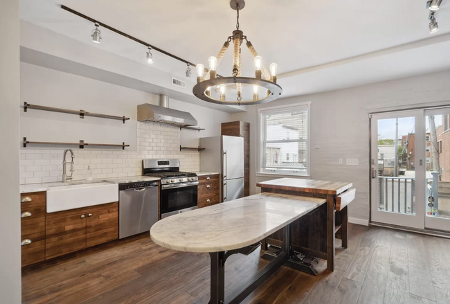 Farmhouse sink with restored wine barrel kitchen cabinets, and custom butcher block island. - 829 3rd St NE