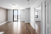 Located at 460 A Belmont Ave W in Kitchener, Ontario, this modern one-bedroom, one-bathroom unit offers a well-designed open-concept layout with contemporary finishes throughout. Light wood-style flooring flows seamlessly across the entire space, complementing the clean, neutral colour palette.

The kitchen is a standout feature, outfitted with sleek white cabinetry extending to the ceiling, a classic tile backsplash, stainless steel appliances including a refrigerator, electric range, microwave, and dishwasher, and a white quartz peninsula with a double undermount sink. The kitchen opens directly into the living area, creating a bright and functional shared space with floor-to-ceiling sliding glass doors leading to a private balcony with open city views.

The bedroom is a comfortable, well-proportioned room featuring a large window that frames scenic views of the surrounding cityscape, and is finished with the same warm wood flooring found throughout the unit.

The bathroom is finished with large-format tile flooring, a white vanity with storage, and a full soaker tub with an overhead shower and tasteful tile surround. Recessed and flush-mount lighting throughout the unit adds to the clean, modern aesthetic of this thoughtfully designed Kitchener residence.