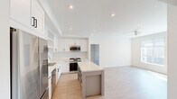 This well-designed 2-bedroom, 2-bathroom residence offers a clean, contemporary aesthetic throughout its single-floor layout. The open-concept kitchen and living area serves as the heart of the home, featuring white shaker-style cabinetry extending to the ceiling, light-toned quartz countertops, a subway tile backsplash, and a central island ideal for dining or meal prep. Stainless steel appliances — including a gas range, built-in microwave, dishwasher, and refrigerator — complete the modern kitchen. Light hardwood-style flooring flows throughout the main living areas, enhancing the bright, airy atmosphere created by recessed lighting and large windows. The living room is equipped with a ceiling fan and provides direct access to an outdoor balcony through a glass door, allowing for natural light and outdoor views. Both bedrooms are carpeted and feature ceiling fans and windows with exterior views. The primary bedroom offers a generous footprint with a dedicated closet. Each of the two bathrooms is finished with a full soaking tub and shower combination set against white tile surrounds, wood-look flooring, and clean white walls. Two closets provide ample storage throughout the residence.