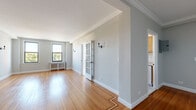Located at 675 N Terrace Ave in Mount Vernon, NY, this well-appointed single-floor residence combines classic architectural details with a clean, neutral aesthetic throughout. Rich hardwood flooring runs through the main living areas and bedrooms, lending warmth and continuity to the space. Crown molding and crisp white baseboards add a refined touch to each room.

The spacious living area is highlighted by elegant French doors, wall sconces, and a decorative inlaid wood border on the floor, creating a polished focal point. Natural light pours in through large windows, offering pleasant views of the surrounding neighborhood's mature tree canopy. A radiator with a decorative cover adds a classic architectural charm.

The galley-style kitchen is efficiently designed with warm wood cabinetry, white subway tile backsplash, light countertops, white tile flooring, and a gas range. Dual windows brighten the space and an overhead chandelier adds a decorative touch. Ample upper and lower cabinet storage makes this kitchen both functional and organized.

The bathroom retains its vintage character with full mint-green tile surround, a classic black tile border, a checkered tile floor, and a soaking tub beneath a window. The bedrooms are generously proportioned, bright, and neutrally finished, each featuring hardwood floors and windows with natural views. A long entry hallway with crown molding and a paneled door completes this thoughtfully designed residence.