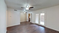 Located at 5303 11th Street in Lubbock, TX, this single-story home offers a practical and comfortable layout with consistent finishes throughout. The main living area is generously sized, showcasing rich, dark hardwood flooring and a textured ceiling with a ceiling fan overhead. French doors lead directly to an outdoor area, allowing natural light to fill the space and providing convenient exterior access. A secondary room adjacent to the living area mirrors the same flooring and ceiling fan, offering flexible use as a formal dining or additional living space.

The kitchen features classic wood cabinetry with ample upper and lower storage, light countertops, a double basin sink, and white appliances including an electric range and refrigerator. The dark hardwood floors continue into this space, maintaining a cohesive look throughout the common areas.

The bedrooms are carpeted for added comfort, each equipped with ceiling fans and built-in closet storage. One bedroom includes a walk-in closet, while another features a standard reach-in closet. The bathroom includes a full tub and shower combination with clean white finishes. Overall, the home presents a straightforward, functional design with practical amenities throughout.