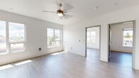 Located at 105 N Killingsworth St in Portland, Oregon, this two-bedroom unit offers a clean, modern design across a single floor. The open layout is characterized by crisp white walls, light wood-style luxury vinyl flooring, and recessed lighting throughout, creating a bright and airy atmosphere. The living area benefits from multiple windows that invite generous natural light and overlook the surrounding Portland neighborhood, while a ceiling fan adds both comfort and style overhead.

The kitchen is efficiently designed with gray shaker-style cabinetry, open shelving, light countertops, a stainless steel sink, a built-in cooktop, a microwave, and a full-size refrigerator — all arranged along a single wall for a streamlined, functional workspace.

The primary bedroom offers a comfortable footprint with large windows framing pleasant neighborhood views. The second bedroom is similarly well-lit, with corner windows providing additional natural light and outdoor sightlines. A dedicated storage area with built-in wire shelving provides practical organization space.

Throughout the unit, the consistent use of neutral tones, modern fixtures, and durable flooring gives the space a cohesive, contemporary feel well-suited to urban living in North Portland.