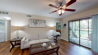 Located at 1000 Stonebrook Dr in Sanford, Florida, this single-floor residence offers a thoughtfully designed layout with a blend of comfort and functionality. The living room serves as the heart of the home, featuring rich hardwood flooring, a ceiling fan with light fixture, and a sliding glass door that opens to a private outdoor patio, bringing in natural light and a seamless indoor-outdoor connection.

Adjacent to the living area, the dining space accommodates a full-sized table and chairs beneath neutral-toned accent walls, with hardwood floors continuing throughout. The kitchen is equipped with dark espresso cabinetry, dark granite countertops, and stainless steel appliances including a gas range, built-in microwave, and refrigerator, all complemented by warm wood-tone flooring.

The home includes two bedrooms, each with its own distinct character. One features sage green accent walls and plush carpet, while the other showcases a bold terracotta accent wall with a bright window. Both bathrooms are finished with dark vanity cabinetry, dark countertops, large mirrors, and a tub-shower combination. A dedicated laundry room with full-size washer and dryer adds everyday convenience to this well-rounded residence.