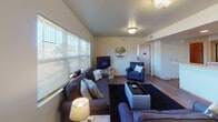 Located at 1135 State St in La Crosse, Wisconsin, this single-floor unit offers a well-organized and functional layout designed for comfortable everyday living. The open-concept living area is bright and inviting, featuring warm-toned hardwood-style flooring, flush-mount ceiling lighting, and large windows that allow generous natural light to fill the space. A comfortable seating arrangement centers the living room, which flows seamlessly into the kitchen via a peninsula counter.

The kitchen is fully equipped with oak cabinetry, a full-sized refrigerator, electric range, microwave, dishwasher, and ample countertop and storage space. A skylight fixture above the kitchen adds additional illumination to the workspace.

Each bedroom is thoughtfully appointed with a built-in desk area situated beneath a window — ideal for studying or working from home — along with a closet and hardwood-style flooring. The rooms offer a cozy and functional atmosphere with ceiling fans providing added comfort.

The unit includes two bathrooms, each featuring warm oak cabinetry, generous vanity counter space, large mirrors, and hardwood-style flooring. One bathroom includes a shower-tub combination. Both bathrooms are well-lit and efficiently laid out. Overall, the unit presents a cohesive, practical design well-suited for shared or individual occupancy in a convenient La Crosse location.