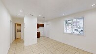 Located at 7130 W 11th Ct in Hialeah, FL, this single-story apartment offers a functional and straightforward layout across two bedrooms and two bathrooms. Light beige ceramic tile flooring runs consistently throughout the entire unit, creating a cohesive and easy-to-maintain interior. The living room is bright and welcoming, featuring recessed ceiling lights and two windows fitted with blinds that allow natural light to fill the space while maintaining privacy. The open sightlines connect seamlessly to the adjacent areas of the unit. Both bedrooms are clean and simply designed with crisp white walls, tile flooring, and standard ceiling fixtures. The primary bedroom includes a window that brings in natural light, while the second bedroom offers a more enclosed feel with a closet door. Each room provides a blank canvas well-suited for personalization. The two bathrooms are a standout feature, showcasing classic light blue square wall tiles that extend from the floor to mid-wall, contrasted by white fixtures including a combination bathtub and shower, pedestal-style sink, and toilet. A large mirror above the sink enhances the sense of space. The unit also includes a visible electrical panel, recessed lighting in the main living areas, and ceiling vents for climate control throughout.