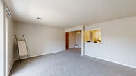 This single-floor residence on Wimbledon Court in Evansville, Indiana, offers a well-organized layout designed for comfortable everyday living. The main living area is spacious and open, featuring neutral-toned carpet throughout and a pass-through window that connects directly to the kitchen, allowing light and visibility to flow between the two spaces. The kitchen is efficiently designed with white cabinetry accented by dark hardware, light wood-look flooring, a built-in dishwasher, a refrigerator, and ample counter space. An adjacent dining area is illuminated by a ceiling light fixture and opens conveniently into the kitchen. A carpeted hallway leads to multiple bedrooms, each finished with soft carpet, neutral walls, and windows fitted with blinds that allow for natural light and privacy. One room benefits from a sliding glass door that opens to a private balcony with outdoor views. The bathroom features a white vanity with dark granite-style countertop, lighted mirror, and wood-look flooring. Throughout, the space maintains a clean, neutral palette with consistent finishes, creating a cohesive and functional environment.