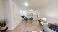 Located on Caminito Cantilena in San Diego, CA, this single-story residence offers a thoughtfully designed open-concept layout that seamlessly connects the main living areas. Light wood-style flooring flows throughout the common spaces, enhancing the bright and airy atmosphere created by abundant natural light from large windows with vertical blinds.

The living room is a welcoming focal point, featuring a fireplace and a generous window that frames views of the surrounding greenery. Adjacent to it, the dining area provides a comfortable gathering space that transitions naturally into the kitchen. The kitchen is well-appointed with white shaker-style cabinetry, granite-look countertops, a stainless steel refrigerator, gas range, and over-the-range microwave, along with a peninsula that opens toward the dining space.

The bathroom features a dual-sink vanity with granite countertops, a large wall mirror with vanity lighting, and a walk-in shower with sliding glass doors. The bedroom includes a spacious walk-in closet with built-in shelving and hanging rods, offering ample storage. An additional room, carpeted and bright with a window overlooking the outdoors, provides flexible use as a bedroom or office. The overall ambiance is clean, neutral, and move-in ready.