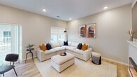 This contemporary Maple Model home offers 1180 square feet of thoughtfully designed living space spread across two floors. The property boasts 2 bedrooms and 3 bathrooms, providing ample space for comfortable living.

The heart of the home is the open-concept kitchen and living area. The kitchen features sleek gray cabinetry, white countertops, and a subway tile backsplash, complemented by black appliances. A round dining table seamlessly integrates into the space, perfect for casual meals or entertaining.

The living room is bathed in natural light from large windows and sliding glass doors, which likely lead to an outdoor area. It's furnished with a plush L-shaped sofa in cream, accented by colorful throw pillows, and modern abstract artwork adorns the walls.

The primary bedroom, measuring 150 square feet, offers a serene retreat with a ceiling fan, large window, and ample space for a queen-sized bed and additional seating. The bathrooms feature contemporary fixtures, including vanities with ample storage and sleek shower units.

Throughout the home, warm wood-look flooring creates a cohesive and inviting atmosphere. Recessed lighting and neutral wall colors further enhance the modern, airy feel of the space. With its efficient layout and stylish finishes, this Maple Model home presents an attractive option for those seeking a contemporary living experience.