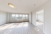 Located at 801 North Broad Street in Elizabeth, NJ, this well-appointed two-bedroom, one-bathroom unit offers a clean, modern aesthetic throughout its single-floor layout. Light-toned wood-style flooring runs continuously through the space, complementing the crisp white walls and creating a bright, cohesive atmosphere.

The spacious living room is bathed in natural light through a large bank of windows, offering open views of the surrounding neighborhood and greenery. The kitchen is thoughtfully designed with two-tone cabinetry — dark lower cabinets paired with white upper cabinets — white quartz countertops, and a full suite of stainless steel appliances including a gas range, dishwasher, and over-the-range microwave.

The generously sized primary bedroom features wide windows with exterior views, providing excellent natural light and a sense of openness. The second bedroom is equally well-lit, with large windows and light-filled interiors. Both rooms are served by an impressive seven closets throughout the unit, offering exceptional storage.

The bathroom includes a tub-shower combination with elegant tiled surround featuring a decorative mosaic accent border. A dedicated in-unit laundry area adds everyday convenience. The unit's clean, neutral palette and modern finishes make it a move-in-ready home.