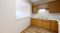 Located at 434 W 4th St in Red Wing, Minnesota, this single-floor, 1-bedroom, 1-bathroom residence offers a practical and comfortable layout designed for efficient living. The kitchen is well-equipped with warm oak cabinetry, a double-basin sink, light countertops, and full white appliances including a range, over-the-range microwave, and refrigerator. A pass-through window connects the kitchen to the adjacent living area, enhancing the sense of openness and allowing natural light to flow between spaces. The living room features durable wood-look flooring and receives generous natural light through a large window, creating a bright and welcoming atmosphere. The bedroom is a comfortable size, finished with plush carpet, a double sliding-door closet, and a sun-filled window with blinds. Two additional closets throughout the unit provide ample storage. The bathroom is clean and functional, featuring wood-look flooring, an oak vanity with a single sink, a mirrored medicine cabinet, and a walk-in shower with a grab bar. Neutral tones and consistent warm wood accents throughout the unit create a cohesive and inviting interior aesthetic.
