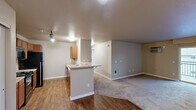Located in Spokane, WA, this well-appointed 3-bedroom, 2-bathroom residence offers a practical and comfortable single-floor layout. The open-concept heart of the home seamlessly connects the kitchen, dining, and living areas, creating a versatile space ideal for both daily living and entertaining. The kitchen is outfitted with warm wood cabinetry, black appliances including a range, microwave, refrigerator, and dishwasher, complemented by light countertops and hardwood-style flooring. Track lighting adds a functional, modern touch overhead. The expansive living area transitions to soft carpeting, providing a comfortable and inviting atmosphere, and opens to a private balcony. The generously sized primary bedroom offers a peaceful retreat, while the two additional bedrooms feature carpeted floors, natural light from windows, and baseboard heating. Two full bathrooms include wood-toned vanities with ample counter space and tub/shower combinations. A dedicated in-unit laundry room houses side-by-side washer and dryer units with overhead shelving for added convenience. Four closets distributed throughout ensure plentiful storage. Neutral wall tones and clean white trim create a cohesive, move-in-ready aesthetic throughout the entire residence.