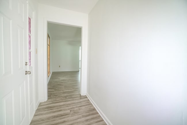 Bright entryway with modern flooring leading to the living room, dining, and kitchen areas. Clean wh - 2313 Salem West Dr