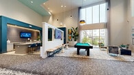 Located at 18210 Park Row Dr in Houston, TX, this impressive two-floor amenity facility spans a generous footprint across both levels, offering a well-rounded recreational and social environment. The main level commands attention with its dramatic double-height ceilings, floor-to-ceiling windows that flood the interior with natural light, and sweeping views of the surrounding exterior. A central lounge area anchors the space, featuring a billiard table set atop a patterned area rug, modern pendant lighting in mixed shapes and finishes, and a curated gallery of framed artwork along the walls. A sleek wet bar with teal accent walls, vertical tile backsplash, under-cabinet lighting, and a large island with plush blue upholstered barstools provides an ideal social gathering spot. Adjacent seating nooks offer more intimate settings with contemporary lounge chairs and sculptural décor. A dedicated bowling alley extends the recreational offerings, complete with polished hardwood lanes, a vibrant neon sign, colorful bowling ball racks, built-in seating with open shelving, and a pinball machine area accented by a bold multicolored feature wall. Hallways connecting the zones are thoughtfully appointed with abstract art and comfortable seating. The upper floor adds additional square footage, enhancing the overall versatility of this well-appointed amenity space.