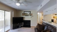 Located in Fayetteville, North Carolina, this single-floor home offers a well-designed layout that combines comfort and functionality. The living room serves as the heart of the space, centered around a classic fireplace with a clean white mantel, decorative mirror, and accent candle holders that add a warm, inviting touch. A ceiling fan overhead ensures year-round comfort, while neutral-toned walls and light carpet flooring create a bright, cohesive atmosphere throughout. The room provides ample space for seating and entertainment, with an open sightline into an adjoining hallway and additional living areas, suggesting a smooth and connected floor plan. The textured ceiling adds a subtle architectural detail consistent throughout the home. Natural flow between rooms is a defining characteristic of this layout, making it practical for everyday living. The overall ambiance is warm and homey, with a neutral color palette that offers versatility for a variety of interior styles. This Fayetteville residence presents a straightforward and functional single-level living experience well-suited for those seeking a comfortable and accessible home.