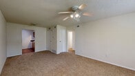 Located at 533 N Somerset Terrace in Olathe, Kansas, this single-floor, 3-bedroom unit offers a practical and comfortable layout. Throughout the living areas and bedrooms, warm neutral-toned carpet provides a cohesive look, complemented by clean white walls and textured ceilings. The main living area is highlighted by a ceiling fan with integrated lighting and a large window fitted with blinds, allowing ample natural light to fill the space. The generously sized primary bedroom features its own window with outdoor views and a sliding-door closet for convenient storage. The additional bedrooms are well-proportioned, each with carpeted floors, natural light from windows with blinds, and dedicated closet space — one bedroom offering a walk-in closet with built-in shelving. The kitchen is efficiently designed in a galley-style layout, featuring warm wood-toned cabinetry, dark countertops, a double-basin sink, and wood-look flooring that adds a contrasting warmth to the space. White appliances including a refrigerator, stove, and dishwasher are all included. A bathroom with basic fixtures completes the floor plan. The overall ambiance is clean, bright, and move-in ready, making this a functional and comfortable home.