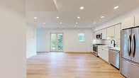 Located at 716 L St SE, Unit 304 in Washington, DC's vibrant Capitol Hill neighborhood, this thoughtfully designed unit offers a clean, contemporary aesthetic throughout its single-floor layout. Light hardwood flooring flows seamlessly from room to room, complemented by crisp white walls and recessed lighting that create a bright, airy atmosphere.

The open-concept living and kitchen area serves as the heart of the unit. The kitchen is outfitted with floor-to-ceiling cream cabinetry, a herringbone tile backsplash, sleek white quartz countertops, a matte black faucet, and a full suite of stainless steel appliances including a gas range, built-in microwave, dishwasher, and refrigerator. French doors open directly to a private balcony, flooding the living space with natural light and offering treetop views.

The bedroom features a large window with neighborhood views and a well-organized sliding-door closet with built-in shelving. An additional flexible room with recessed lighting provides versatile space for a home office or guest room. The bathroom is elegantly appointed with a warm wood vanity, white tile flooring, and a frameless glass-enclosed shower with full-height tile surround and matte black hardware fixtures throughout.