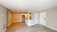 Located at 2821 Pheasant Hollow Dr in Plainsboro, NJ, this two-bedroom residence offers a well-designed single-floor layout with a clean, modern aesthetic throughout. Light hardwood-style flooring runs continuously across the space, complementing the neutral warm-gray walls and crisp white trim.

The open-concept living room is bright and airy, with a sliding glass door that leads to a balcony and offers views of the surrounding greenery. The kitchen is thoughtfully appointed with white shaker-style cabinetry, granite countertops, a subway tile backsplash, and stainless steel appliances including a refrigerator, electric range, microwave, and dishwasher. A peninsula counter provides a casual dining or prep area and visually connects the kitchen to the living space.

The spacious primary bedroom offers generous square footage and features two closets, including a walk-in closet with built-in racking. The second bedroom is well-sized with a large window that brings in natural light and outdoor views. Two dedicated closets throughout the unit provide ample storage. The overall ambiance is clean, bright, and move-in ready, reflecting a freshly updated interior with modern finishes in a quiet Plainsboro community.