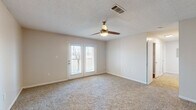 This single-floor home in Walls, Mississippi, features a practical and classic layout designed to maximize functionality across its three bedrooms and two bathrooms. The living room serves as the central gathering space, finished with plush carpeting, a ceiling fan with integrated lighting, and a textured ceiling. French doors allow natural light to fill the room and provide direct outdoor access. The front entry area transitions seamlessly from hardwood-style flooring into the carpeted living space.

The kitchen is efficiently organized with white cabinetry, warm hardwood-style flooring, stainless steel appliances including a refrigerator, range, and built-in microwave, and ample counter space. It connects directly to the dining area, creating a cohesive space for everyday living.

The three bedrooms are carpeted and neutrally toned. The primary bedroom features a ceiling fan and two closets for generous storage. Additional bedrooms offer hardwood-style flooring and clean, understated finishes. Both bathrooms mirror each other in design, featuring hardwood-style flooring, white vanities, and towel bar fixtures, maintaining a consistent, classic aesthetic throughout the home.