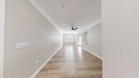 This renovated 1-bedroom, 1-bathroom apartment at 900 Channing Way in Goose Creek, SC offers 680 square feet of thoughtfully designed living space. The open-concept kitchen and living area features light wood-tone laminate flooring throughout, creating a cohesive and modern aesthetic. The kitchen is equipped with stainless steel appliances — including a refrigerator, electric range, microwave, and dishwasher — complemented by light wood cabinetry, white quartz countertops, a white subway tile backsplash, and a peninsula with an undermount sink fitted with a matte black faucet. An arched architectural detail adds a classic touch to the kitchen's transition into the living area. The spacious living room is illuminated by a ceiling fan with light fixture and benefits from ample natural light. The 140-square-foot primary bedroom features plush carpeting, a ceiling fan, and two windows that invite natural light and outdoor views of surrounding greenery. A dedicated closet provides convenient storage. Neutral warm-gray walls, white trim, and consistent finishes throughout lend the unit a clean, updated feel well-suited for modern living.