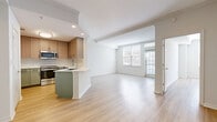 Located in the vibrant McKinney Avenue corridor of Dallas, this two-bedroom, one-bathroom residence offers a thoughtfully designed, single-level layout with a clean, contemporary aesthetic throughout. Light wood-tone flooring runs continuously through the open-concept living and dining area, creating a bright and cohesive feel complemented by recessed lighting and large windows that draw in natural light.

The kitchen is a standout feature, showcasing a two-tone design with sage green lower cabinets, warm wood upper cabinetry, white quartz countertops, a peninsula with an undermount sink, and a full suite of stainless steel appliances including a range and over-the-range microwave. A dedicated laundry area houses a full-size washer and dryer alongside a water heater for added convenience.

The generously sized primary bedroom offers ample space and is accompanied by a large walk-in closet with wire shelving. A second bedroom provides flexibility, featuring elegant French doors with glass pane inserts that enhance the sense of openness. Three closets throughout the residence ensure excellent storage capacity. The bathroom features clean, neutral finishes consistent with the home's modern design. The overall ambiance is light, airy, and move-in ready.