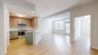 Located in the vibrant McKinney Avenue corridor of Dallas, this two-bedroom, one-bathroom residence offers a thoughtfully designed, single-level layout with a clean, contemporary aesthetic throughout. Light wood-tone flooring runs continuously through the open-concept living and dining area, creating a bright and cohesive feel complemented by recessed lighting and large windows that draw in natural light.

The kitchen is a standout feature, showcasing a two-tone design with sage green lower cabinets, warm wood upper cabinetry, white quartz countertops, a peninsula with an undermount sink, and a full suite of stainless steel appliances including a range and over-the-range microwave. A dedicated laundry area houses a full-size washer and dryer alongside a water heater for added convenience.

The generously sized primary bedroom offers ample space and is accompanied by a large walk-in closet with wire shelving. A second bedroom provides flexibility, featuring elegant French doors with glass pane inserts that enhance the sense of openness. Three closets throughout the residence ensure excellent storage capacity. The bathroom features clean, neutral finishes consistent with the home's modern design. The overall ambiance is light, airy, and move-in ready.