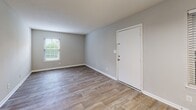 Located at 1 Bosquet Ct in Summerville, South Carolina, this single-floor residence offers a thoughtfully designed layout with clean, modern finishes throughout. The entry opens into a bright living area featuring wood-look plank flooring, neutral gray walls, white baseboards, and a textured ceiling. Natural light filters in through blinded windows, creating a welcoming atmosphere from the moment you step inside.

The kitchen is equipped with white cabinetry, light stone-patterned countertops, a stainless steel electric range with overhead ventilation, and a full-size refrigerator, providing ample functionality for everyday cooking. Adjacent utility space houses a full-size washer and dryer along with a water heater, adding practical convenience.

The bedrooms are carpeted for comfort and feature neutral tones, natural window light, and sufficient space for furnishings. Each room connects seamlessly to the rest of the home via a central hallway. Two bathrooms serve the residence, each finished with wood-look flooring, white vanity cabinetry, stone-patterned countertops, framed mirrors, and well-lit vanity fixtures. The overall design is consistent and cohesive, emphasizing clean lines and a neutral palette that makes the space highly adaptable to a variety of interior styles.