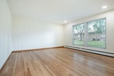 Located at 4716 Regent St in Madison, Wisconsin, this two-bedroom, one-bathroom residence is situated within a classic brick building surrounded by mature trees and well-maintained green lawns. The single-floor layout is thoughtfully designed to maximize comfort and functionality throughout.

The open living and dining area greets you upon entry, featuring warm hardwood flooring that extends throughout the home. Natural light pours in through large windows, offering pleasant views of the lush, tree-lined grounds. The kitchen is well-appointed with white shaker cabinetry, dark granite countertops, and a full suite of stainless steel appliances, including a refrigerator, range, microwave, and dishwasher — ideal for everyday cooking and entertaining.

Both bedrooms are comfortably sized, each equipped with a ceiling fan, hardwood floors, and windows that frame the outdoor greenery. Dedicated closets provide ample storage in each room. The bathroom is cleanly finished with white subway tile surrounding the tub-shower combo, a modern vanity with stone countertop, and brushed nickel fixtures.

Additional highlights include laundry facilities, a hallway connecting the living spaces, and a private patio for outdoor enjoyment. Baseboard heating is present throughout the unit.