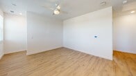 Located at 2186 J Lawson Blvd in Orlando, FL, this two-story home offers a clean, modern aesthetic with thoughtful design details across every room. The main living level hosts the majority of the space, featuring light wood-look flooring that flows seamlessly throughout and a bright, open-concept kitchen as its centerpiece. The kitchen is outfitted with crisp white shaker cabinets, quartz countertops, a large waterfall-edge island, stainless steel appliances, and matte black hardware — a cohesive and stylish combination. Recessed lighting and a window above the sink keep the space well-lit and inviting. Both bedrooms are generously proportioned, each featuring ceiling fans, white walls, and the same warm wood flooring. The primary bedroom includes access to a dedicated closet with built-in wire shelving for organized storage. The two bathrooms mirror the home's modern palette with white vanities, quartz countertops, bold black-framed mirrors, and matte black fixtures. The primary bath features a walk-in tiled shower with a glass door, while the second bathroom offers a single-vanity layout. The ground level houses a spacious attached garage with an automatic opener and interior access. A staircase connects both floors, completing this well-appointed Orlando home.