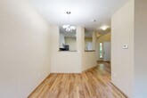 Located in Marysville, Washington, this two-story home offers a well-organized layout spread across two floors. The main level features a combined kitchen and living area anchored by light wood-style flooring throughout. The kitchen is equipped with stainless steel appliances—including a refrigerator, range, and built-in microwave—complemented by white cabinetry, dark countertops, and a practical pass-through design that connects it to the living space. A chandelier adds a subtle decorative touch to the dining area. The living room is bathed in natural light from a large window and sliding glass door that opens directly to an outdoor patio, offering views of a fenced backyard. The upper floor houses the two bedrooms, each finished with plush carpeting and neutral wall tones. The generously sized primary bedroom provides comfortable proportions and ample natural light. Three bathrooms serve the home, with at least one featuring wood-style flooring, a single-sink vanity, and a tub. A dedicated laundry area, hallway, and two closets round out the functional layout. The home maintains a clean, neutral palette throughout, creating a bright and cohesive atmosphere across all levels.