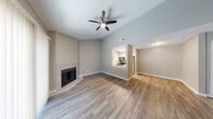 Located at 1111 Vista Valet in San Antonio, TX, this two-story home offers two bedrooms, two bathrooms, and a thoughtfully organized layout spread across two floors. The main level features an open living area with wood-look flooring, soaring vaulted ceilings, and a corner fireplace framed by a large sliding glass door with vertical blinds that fills the space with natural light. A staircase leads to the upper level, reinforcing the home's multi-level character. The kitchen is accessed via a pass-through counter opening, showcasing white cabinetry, granite-style countertops, and stainless steel appliances including a refrigerator, range, and microwave. A dedicated pantry with a double-door closet adds practical storage. Both bedrooms feature wood-look flooring and ceiling fans, providing a comfortable and cohesive feel. The generously sized primary bedroom is located upstairs and includes an en-suite bathroom with a wide vanity, granite countertops, dual mirrors, and modern light fixtures. The second bathroom features floor-to-ceiling tiled walls surrounding a tub-shower combo with chrome fixtures. Throughout, neutral gray tones and clean white trim create a polished, move-in-ready aesthetic.