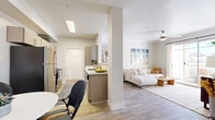 This 2-bedroom, 3-bathroom residence is designed with a modern, open-concept layout that maximizes functionality and comfort. Wood-look flooring flows throughout the entire space, lending warmth and visual continuity from room to room.

The kitchen is a standout feature, equipped with stainless steel appliances, light wood cabinetry, and a clean white quartz peninsula that opens directly to the combined living and dining area. A skylight above the kitchen fills the space with natural light, while a dedicated dining nook with built-in shelving adds both practicality and charm.

The living room is bright and airy, anchored by a ceiling fan and large sliding glass doors that open to a private patio with outdoor seating and views of surrounding greenery. The bedrooms are comfortably proportioned, each offering natural light through window treatments and ample closet space. The primary bedroom suite includes direct access to an ensuite bathroom featuring a floating wood vanity and white quartz countertop.

Three full bathrooms are finished consistently with wood-tone cabinetry, white countertops, and clean tile work. Additional conveniences include a dedicated laundry area, a hallway connecting the main rooms, and two closets. The overall ambiance is light, neutral, and modern throughout.