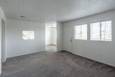 Located at 1439 North Lilac Avenue in Rialto, California, this single-story home offers a practical and well-organized layout across two bedrooms and two bathrooms. The interior is finished with neutral tones throughout, creating a clean and cohesive aesthetic. Soft carpeting runs through the living room and both bedrooms, while the kitchen and bathrooms feature durable light wood-style flooring. The kitchen is designed for efficiency, featuring white cabinetry, light countertops, a double-basin sink, a gas range, and an overhead range hood, all illuminated by a ceiling light fixture. The primary bedroom is a generously sized room with two windows that invite natural light and a sliding closet for ample storage. The second bedroom also benefits from natural light through a window and includes built-in open shelving — a functional and distinctive feature. Both bathrooms are finished in crisp white, each equipped with a tub-shower combination with tile surround, a white vanity, and light wood-style flooring. A textured ceiling is consistent throughout the home. The hallway connects the rooms in a logical flow, contributing to the home's efficient single-floor design.