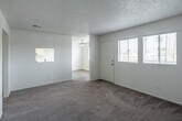 Located at 1439 North Lilac Avenue in Rialto, California, this single-story home offers a practical and well-organized layout across two bedrooms and two bathrooms. The interior is finished with neutral tones throughout, creating a clean and cohesive aesthetic. Soft carpeting runs through the living room and both bedrooms, while the kitchen and bathrooms feature durable light wood-style flooring. The kitchen is designed for efficiency, featuring white cabinetry, light countertops, a double-basin sink, a gas range, and an overhead range hood, all illuminated by a ceiling light fixture. The primary bedroom is a generously sized room with two windows that invite natural light and a sliding closet for ample storage. The second bedroom also benefits from natural light through a window and includes built-in open shelving — a functional and distinctive feature. Both bathrooms are finished in crisp white, each equipped with a tub-shower combination with tile surround, a white vanity, and light wood-style flooring. A textured ceiling is consistent throughout the home. The hallway connects the rooms in a logical flow, contributing to the home's efficient single-floor design.