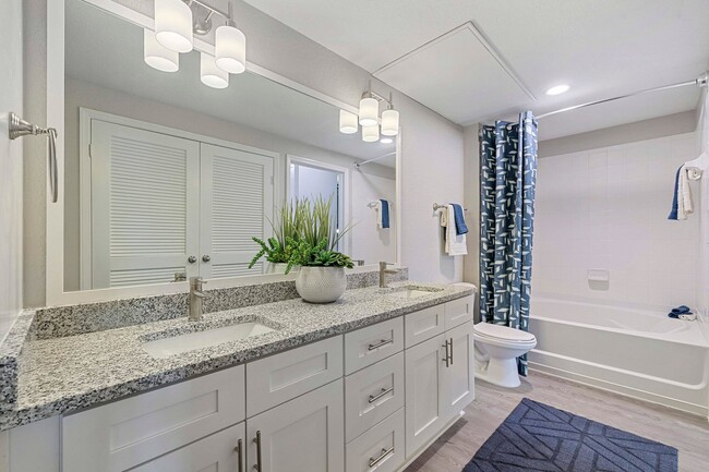 Apartamentos reformados: baños modernos con espejos enmarcados. - Reserve At Beachline Apartments