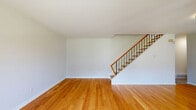 This well-structured three-floor home in Mississauga, Ontario, offers a functional and comfortable layout across three thoughtfully organized levels. Warm-toned hardwood flooring runs throughout the main and upper floors, lending a consistent and inviting character to the living spaces.

The main floor features an open-concept kitchen and living room area, where the kitchen is finished with white cabinetry, subway tile backsplash, light stone countertops, and stainless steel appliances including a dishwasher, all set on neutral tile flooring. The living area benefits from large sliding windows that frame views of lush greenery outside, filling the space with natural light.

The upper floor houses three bedrooms, each finished with the same warm hardwood flooring. The bedrooms are bright and well-proportioned, with windows offering pleasant outdoor views and baseboard heating units throughout. The primary bedroom provides a generous footprint with a closet. Two clean, well-appointed bathrooms serve the home — one featuring a soaker tub with shower, white tile surround, and a small window, and the other a streamlined vanity with a marble-style countertop.

The lower level is an expansive unfinished basement with a painted concrete floor, exposed wood beam ceiling, and laundry facilities, offering significant potential for customization or additional storage.