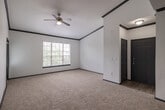 Located at 11111 Grant Rd in Cypress, TX, this single-story residence offers a well-designed layout with a cohesive modern aesthetic throughout. The kitchen is a standout feature, showcasing slate-blue shaker cabinetry, crisp white countertops, a mosaic tile backsplash, stainless steel appliances, and a peninsula with an undermount sink — all set atop light wood-style flooring. Soaring ceilings above the kitchen add a sense of openness that carries through the space. The living and bedroom areas are finished with plush neutral carpeting, dark accent baseboards, and ceiling fans, creating a comfortable and consistent atmosphere. Multiple bedrooms benefit from natural light through blinded windows with outdoor views of the surrounding greenery. At least one bedroom includes a walk-in closet for added storage. The bathrooms feature updated slate-blue vanities with white countertops, light wood-style flooring, and full tub-shower combinations with clean white tile surrounds. A dedicated laundry room with side-by-side washer and dryer and overhead shelving adds everyday convenience. The thoughtful combination of modern finishes and practical amenities makes this a well-appointed and functional single-floor home.