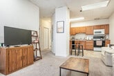 Located at 635 Langdon St in Madison, WI, this three-bedroom, one-bathroom unit is spread across a single floor and offers a functional, well-organized layout. The open-concept living and kitchen area forms the heart of the home, where a structural column subtly defines the two spaces without closing them off. The kitchen is equipped with warm honey-toned wood cabinetry, a full suite of appliances including a range, microwave, and dishwasher, and a tile floor that extends throughout the space. A breakfast bar with stools provides a casual dining option. The living area features plush carpeting and benefits from natural light streaming through a striking arched window — a standout architectural detail that adds character to the space. The front entry also features this same decorative arched window, creating a welcoming first impression. Each of the three bedrooms is carpeted and offers closet storage, with the generously sized primary bedroom showcasing wainscoting details and its own arched window. The shared full bathroom includes a single-sink oak vanity, tiled flooring, and a shower-tub combination. Two hallways connect the rooms efficiently, and a dedicated closet provides additional storage. The drop-panel ceiling with integrated lighting is consistent throughout the unit.