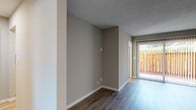 Located at 443 Gateway Dr in Pacifica, CA, this single-story unit presents a clean, updated interior with a cohesive neutral color palette throughout. The living area is finished with warm wood-tone laminate flooring and features a sliding glass door that opens to a private outdoor space enclosed by a wood fence, allowing natural light to filter into the room. A textured ceiling adds dimension to the space, while white baseboards provide a crisp contrast to the taupe-toned walls.

Multiple rooms throughout the unit continue the wood-style flooring and neutral wall tones, creating a consistent and versatile aesthetic. Baseboard heaters are present in several rooms, offering efficient zone heating. One bedroom features a sliding-door closet with a full-width rod, a natural light-filled window with views of the surrounding neighborhood, and direct access to a hallway. Additional rooms benefit from bright, light-toned flooring and generous window placements that invite ample daylight.

The kitchen is efficiently laid out with white cabinetry featuring matte black hardware, light countertops, and an electric range. The bathroom includes a full-size soaking tub and shower combination with chrome fixtures, set against clean white surround walls.