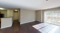 Located at 607 Windview Way in Frederick, Maryland, this single-floor residence offers a thoughtfully designed layout that balances comfort and functionality. The open-concept living and dining area is finished with rich, dark hardwood flooring that extends throughout the main living spaces, creating a warm and cohesive aesthetic. Large sliding glass doors and windows allow natural light to flow generously into the living room, complemented by clean neutral-toned walls and crisp white trim. A track lighting fixture adds a modern touch to the dining area.

The kitchen is both practical and stylish, featuring light maple cabinetry with a built-in wine rack, dark granite-style countertops, black appliances including a range, microwave, dishwasher, and refrigerator, and a peninsula with additional counter space that connects seamlessly to the living area. The hardwood flooring continues throughout the kitchen.

The bedrooms are carpeted for comfort and each include a ceiling fan with light fixture and windows with blinds that overlook the greenery outside. The two bathrooms are finished with light tile flooring, granite-topped vanities with wood cabinetry, and tub-shower combinations with white tile surrounds, offering a clean and functional design throughout.