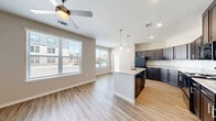 Located at 14201 C.F. Hawn Fwy in Dallas, TX, this single-story, 3-bedroom, 2-bathroom home offers a thoughtfully designed layout with modern finishes throughout. The open-concept living and kitchen area serves as the heart of the home, featuring light luxury vinyl plank flooring, recessed lighting, and large windows that invite abundant natural light. A ceiling fan adds comfort to the living space. The kitchen is well-equipped with dark espresso cabinetry, granite-look countertops, black appliances, pendant lighting, and a central island with a built-in sink — ideal for both cooking and casual dining. Hallways with recessed lighting connect the living areas to the three bedrooms, each featuring ceiling fans, vinyl plank flooring, and windows with exterior views. The spacious primary bedroom includes two closets — a standard closet and a dedicated shelving closet — offering generous storage. The two bathrooms feature dark vanity cabinetry with granite countertops, large mirrors, and tile flooring. One bathroom includes a glass-enclosed walk-in shower with white subway tile and a built-in shelf. Additional highlights include four closets, a dedicated laundry area, and a walk-in closet with wire shelving. The home presents a clean, contemporary aesthetic throughout.