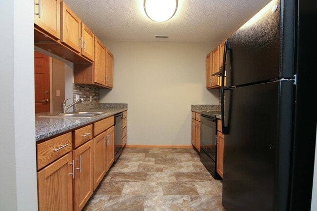 Updated kitchen with sleek black appliances and spacious countertops adorn our renovated apartments. - Northbrook Apartments