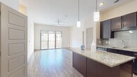 This contemporary 970 square foot apartment at The Flats at Palisades offers a thoughtfully designed living space. The open-concept layout showcases a gourmet kitchen with dark wood cabinetry, stainless steel appliances, and a center island with granite countertops. The kitchen flows seamlessly into the living area, which features wood-look flooring and access to a private balcony.

The two bedrooms are generously sized, with the primary bedroom measuring 140 square feet. Both bedrooms boast plush carpeting and ample natural light. The two full bathrooms are elegantly appointed with modern fixtures, tiled flooring, and spacious vanities.

Additional amenities include in-unit laundry facilities and walk-in closets. The apartment's neutral color palette and abundance of windows create a bright, airy atmosphere throughout. With its blend of style and functionality, this apartment offers a comfortable and contemporary urban living experience.