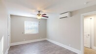 Located at 144 E 62nd St in Savannah, GA, this single-floor unit presents a clean, updated interior with a neutral color palette and consistent design choices throughout. The living areas feature light-toned hardwood-style flooring paired with crisp white baseboards, creating a bright and cohesive atmosphere. Ceiling fans are installed in multiple rooms, complementing a wall-mounted mini-split HVAC system that provides efficient climate control. Natural light enters through blinded windows, adding warmth to the understated, neutral-toned walls.

The kitchen is thoughtfully designed with white cabinetry extending to the ceiling for ample storage, granite countertops, a stainless steel undermount sink with a modern spring-neck faucet, and a full suite of stainless steel appliances including an electric range and over-the-range microwave. The galley-style layout leads directly into the main living area, offering an open and connected flow.

The carpeted bedroom provides a comfortable contrast to the hard flooring found elsewhere and includes a ceiling fan. The bathroom features matching granite countertops on the vanity, wood-style tile flooring, a shower-tub combo, and a window for natural ventilation. Overall, the unit offers a well-maintained, move-in-ready space with modern updates throughout.