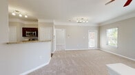Located in Houston, TX, this two-story home offers a thoughtfully arranged layout across two floors. The main living area is bright and open, featuring neutral-toned carpet, crown molding, and a ceiling fan, with natural light flowing in through multiple windows. A door provides convenient exterior access directly from the living space. The kitchen is equipped with rich dark-wood cabinetry, granite-look countertops, stainless steel appliances including a refrigerator and dishwasher, and hardwood-style flooring, creating a functional and attractive cooking space. A carpeted staircase with a clean white railing connects the floors. Upstairs, the primary bedroom is generously sized with a ceiling fan, crown molding, and a large window offering views of lush greenery. Both bedrooms include walk-in closets with wire shelving systems for ample storage. The bathrooms feature hardwood-style flooring, a tub-shower combination with tile surround, and clean, simple finishes. A dedicated laundry room houses a full-size washer and dryer with overhead shelving. Throughout, the home maintains a cohesive, neutral palette with white trim and warm tones, offering a comfortable and move-in-ready environment.