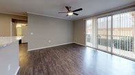This 1-bedroom, 1-bathroom residence in Amherst is designed with a practical and modern aesthetic throughout its single-floor layout. The open living area features rich, dark wood-style flooring, crown molding, and a ceiling fan, creating a warm and inviting atmosphere. A sliding glass door floods the space with natural light while providing outdoor views, enhancing the sense of openness. Built-in shelving adds a thoughtful architectural detail to the living space.

The kitchen is efficiently designed in a galley-style configuration, featuring dark espresso cabinetry, marble-look countertops, and a full suite of stainless and black appliances including a refrigerator, electric range, microwave, and dishwasher. A peninsula pass-through connects the kitchen to the living area, improving flow and functionality. A dedicated storage closet is accessible directly from the kitchen.

The bedroom offers plush carpeting, a ceiling fan, a spacious walk-in closet, and built-in wall shelving, providing ample storage and comfort. The bathroom is appointed with wood-look tile flooring, a dark vanity with marble-style countertop, and a full soaking tub with white subway tile surround. The overall design palette of neutral tones and contemporary finishes gives the unit a clean, cohesive feel throughout.