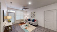 This thoughtfully designed single-floor residence offers a cohesive open-concept layout that seamlessly connects the main living areas. The living room is bright and welcoming, featuring wood-look plank flooring, crown molding, a ceiling fan, and large windows dressed with horizontal blinds that allow natural light to fill the space. A transom window above the front door adds an additional touch of architectural detail.

The kitchen is a standout feature, equipped with dark espresso cabinetry, granite countertops, a subway tile backsplash, stainless steel appliances, and a central island with sink — ideal for both cooking and casual dining. Just off the kitchen, a dedicated built-in desk nook with open shelving provides a functional and stylish home office area.

The bedroom is carpeted for comfort and includes a ceiling fan, multiple windows for natural light, and direct access to the bathroom. The bathroom mirrors the kitchen's design aesthetic with granite countertops, dark cabinetry offering ample storage, and a well-lit vanity mirror. Consistent use of neutral tones and quality finishes throughout creates a cohesive and polished ambiance across the entire residence.