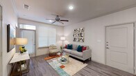 This thoughtfully designed single-floor residence offers a cohesive open-concept layout that seamlessly connects the main living areas. The living room is bright and welcoming, featuring wood-look plank flooring, crown molding, a ceiling fan, and large windows dressed with horizontal blinds that allow natural light to fill the space. A transom window above the front door adds an additional touch of architectural detail.

The kitchen is a standout feature, equipped with dark espresso cabinetry, granite countertops, a subway tile backsplash, stainless steel appliances, and a central island with sink — ideal for both cooking and casual dining. Just off the kitchen, a dedicated built-in desk nook with open shelving provides a functional and stylish home office area.

The bedroom is carpeted for comfort and includes a ceiling fan, multiple windows for natural light, and direct access to the bathroom. The bathroom mirrors the kitchen's design aesthetic with granite countertops, dark cabinetry offering ample storage, and a well-lit vanity mirror. Consistent use of neutral tones and quality finishes throughout creates a cohesive and polished ambiance across the entire residence.