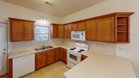 Located at 183 Clusters Cir in Mooresville, NC, this two-story home offers a well-organized layout across both levels. The living room is a comfortable, carpeted space brightened by multiple windows and equipped with a ceiling fan, opening directly to the kitchen and dining areas for a connected flow.

The kitchen features warm-toned wood cabinetry with ample storage, light countertops, a double-basin sink, and white appliances including a range, built-in microwave, and dishwasher. Tile flooring and a window above the sink add practicality and natural light. Adjacent to the kitchen, the dining area is finished with matching tile flooring and anchored by a classic brass chandelier.

The bedrooms are carpeted and include ceiling fans and windows that invite natural light. One room features a built-in workstation with rich wood cabinetry, open shelving, and a wide countertop surface with integrated cable management — a functional dedicated workspace.

The bathrooms include a full bath with a tub-shower combination and vanity with wood cabinetry, as well as a secondary bath offering an extended vanity and a spacious closet. Throughout the home, consistent finishes such as brass fixtures and panel doors provide a cohesive aesthetic.