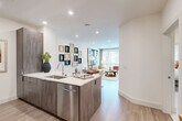 Located in Charlotte's vibrant South End neighborhood, this 1-bedroom, 1-bathroom residence offers a thoughtfully designed open-concept layout that maximizes every square foot. Light wood-style flooring flows throughout, complementing the clean, modern aesthetic found in every room.

The kitchen is a functional centerpiece, featuring sleek wood-grain cabinetry, white quartz countertops, a stainless steel appliance suite including a French door refrigerator, microwave, and range, and a peninsula with an undermount sink that opens seamlessly to the dining and living areas. A built-in desk nook provides a convenient workspace just off the kitchen.

The living room is bright and inviting, with large floor-to-ceiling windows and access to a private balcony that fills the space with natural light and outdoor views. Recessed lighting and crisp white walls enhance the open, airy atmosphere.

The bedroom offers a comfortable retreat with a ceiling fan, generous window with exterior views, and two closets for ample storage. A hallway with elegant marble-look tile flooring leads to the full bathroom, with additional closet access along the way.

This residence combines modern finishes with a practical, well-organized floor plan, making it an ideal home in one of Charlotte's most sought-after locations.